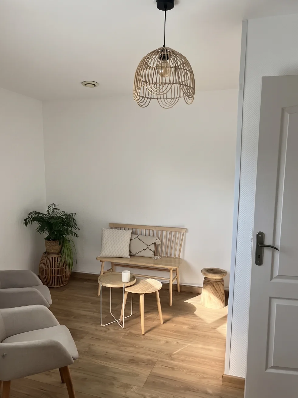 Un salon avec un canapé, une table basse et un lampadaire en osier.